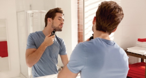 Here is a man trimming his beard with a Philips Norelco Multigroom Series 3100 Beard Trimmer