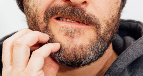 Homme se grattant la barbe et souffrant de démeangeaison de la barbe