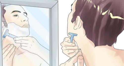 Here is a man shaving himself with a safety double-edge razor while looking him in the mirror
