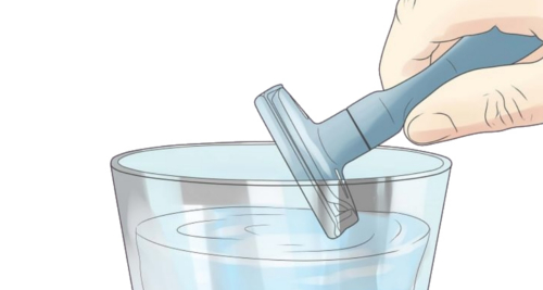 Here is a double-edged safety razor and a glass of water to clean it after each shaving stroke.