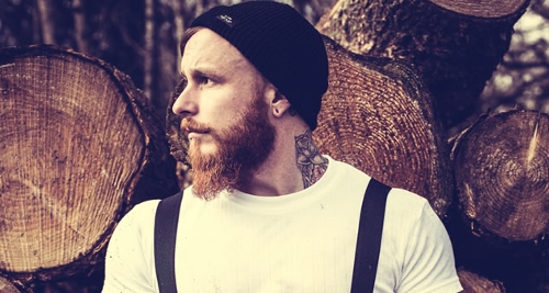 Here is a ginger beard man with wood background