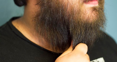 Here is a man applying beard balm