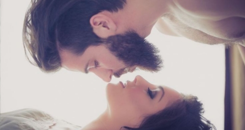 Here is a bearded man kissing a woman